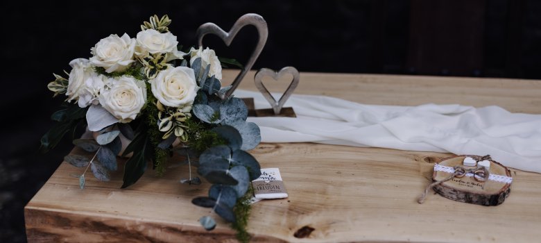 Brautstrauß und Ringe auf dem Tisch
